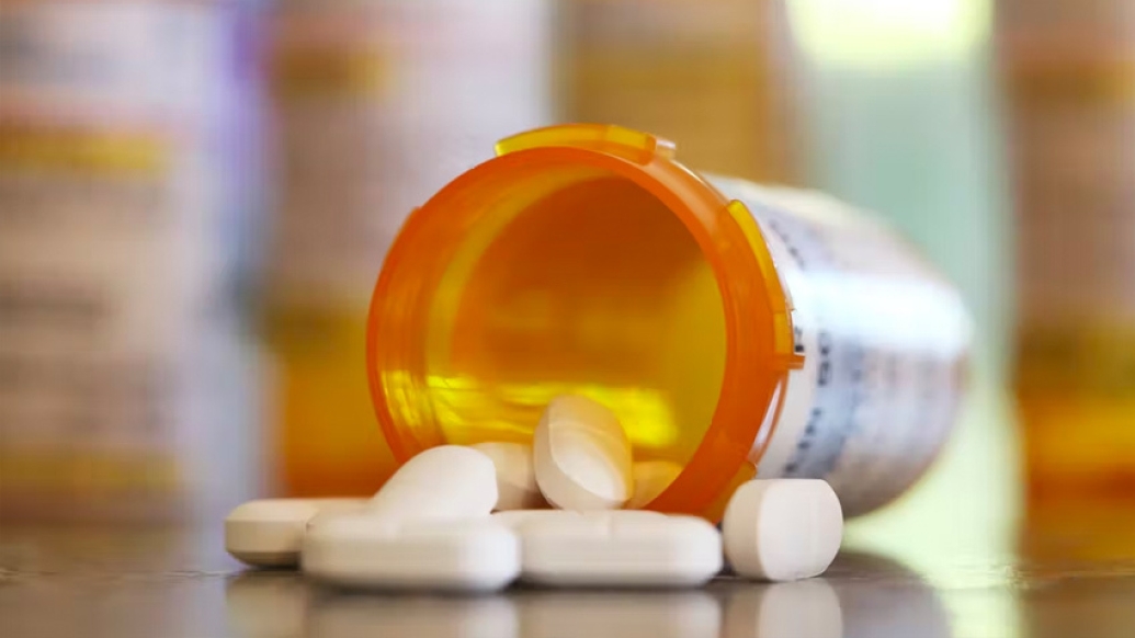 pills meds falling out on table orange bottle white pills