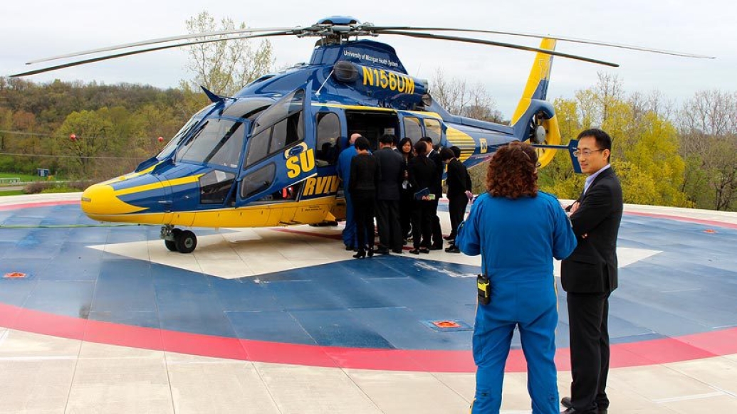 team standing outside in helicopter on helipad